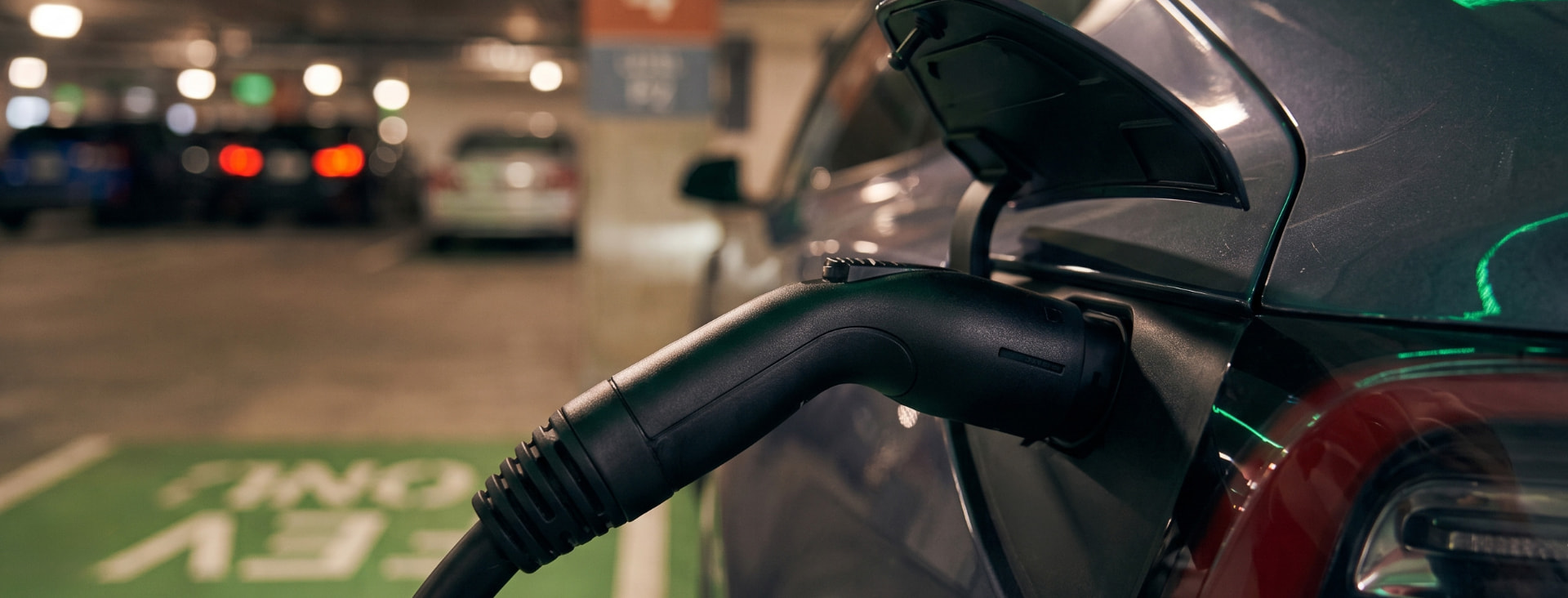 EV charger plugged into a car in the parking garage